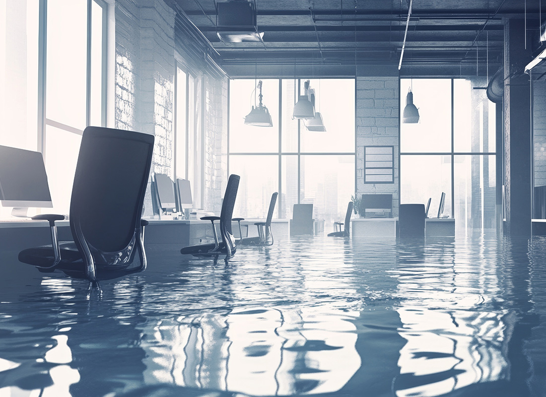 Chairs floating in a flooded office space, depicting the afterma disaster recovery for SMBs. Lessons Learned Hurricane 2024