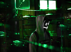 cyber criminal in a darkly lit room surrounded by computers